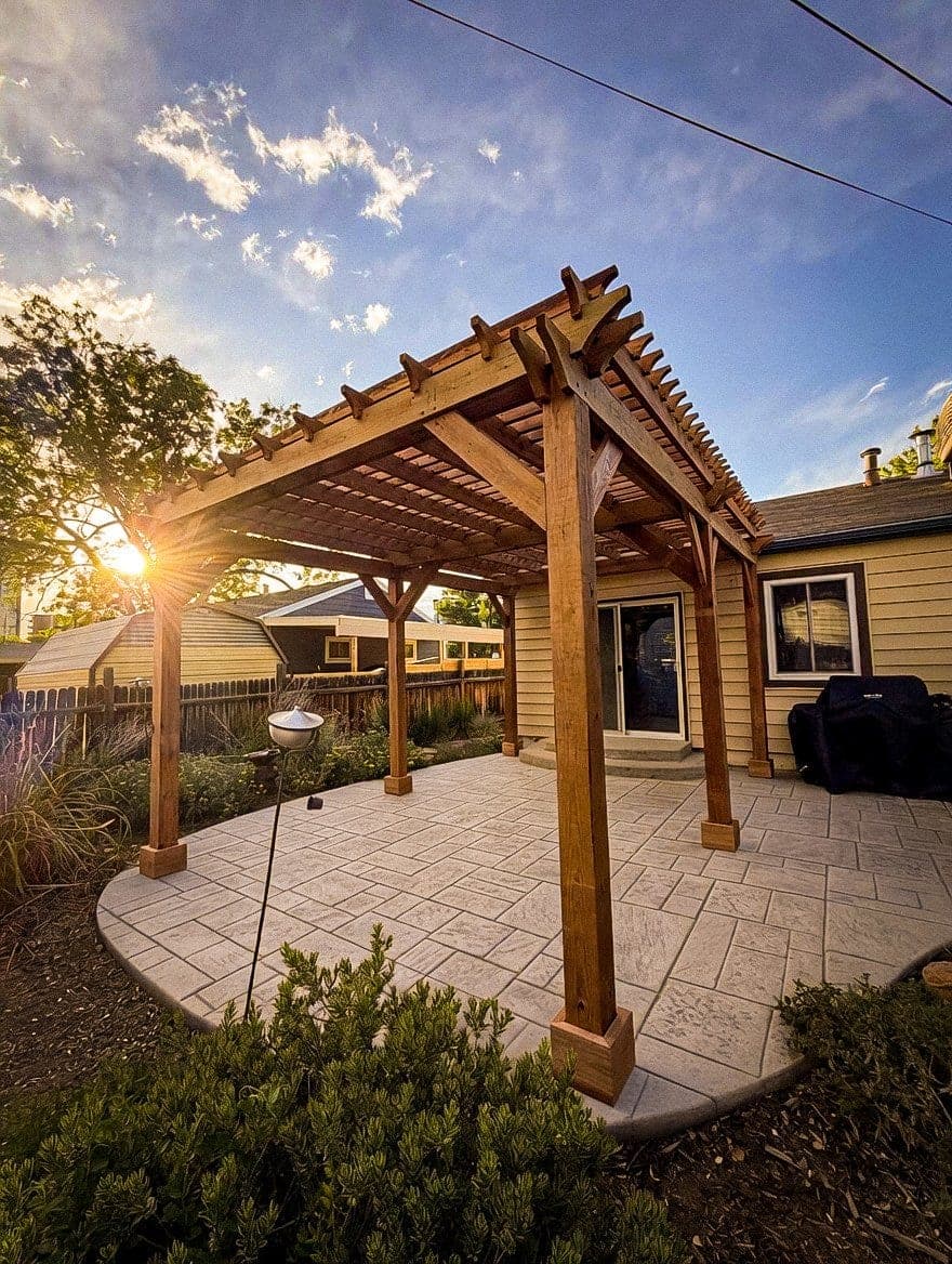 Custom stained wood pergola over stamped concrete patio