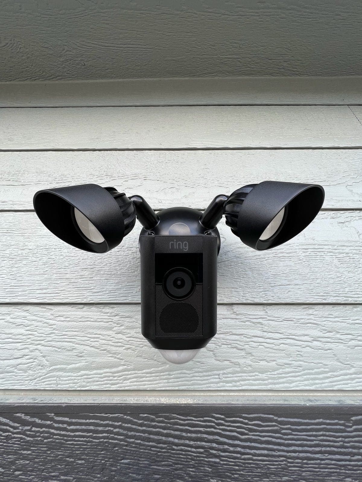 Ring floodlight camera on white siding